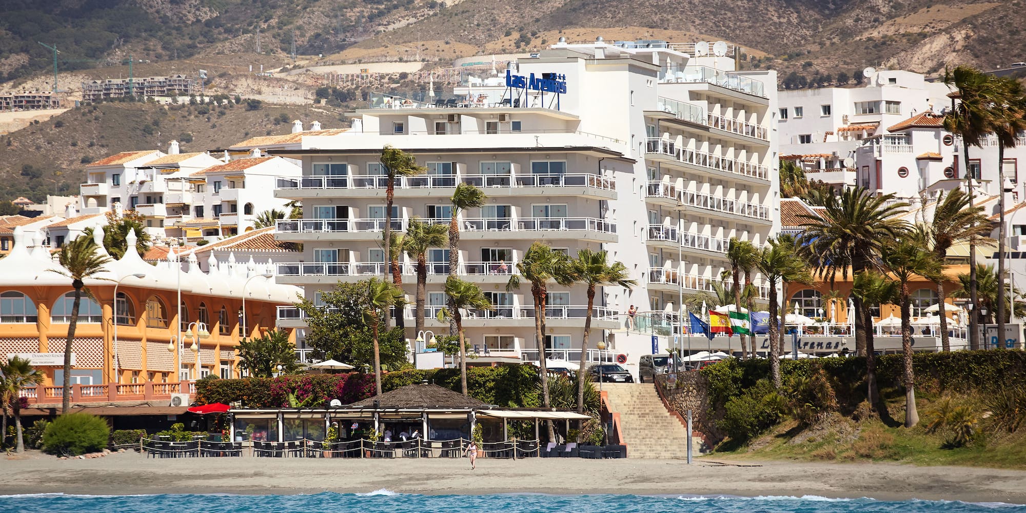 a beach with buildings and trees