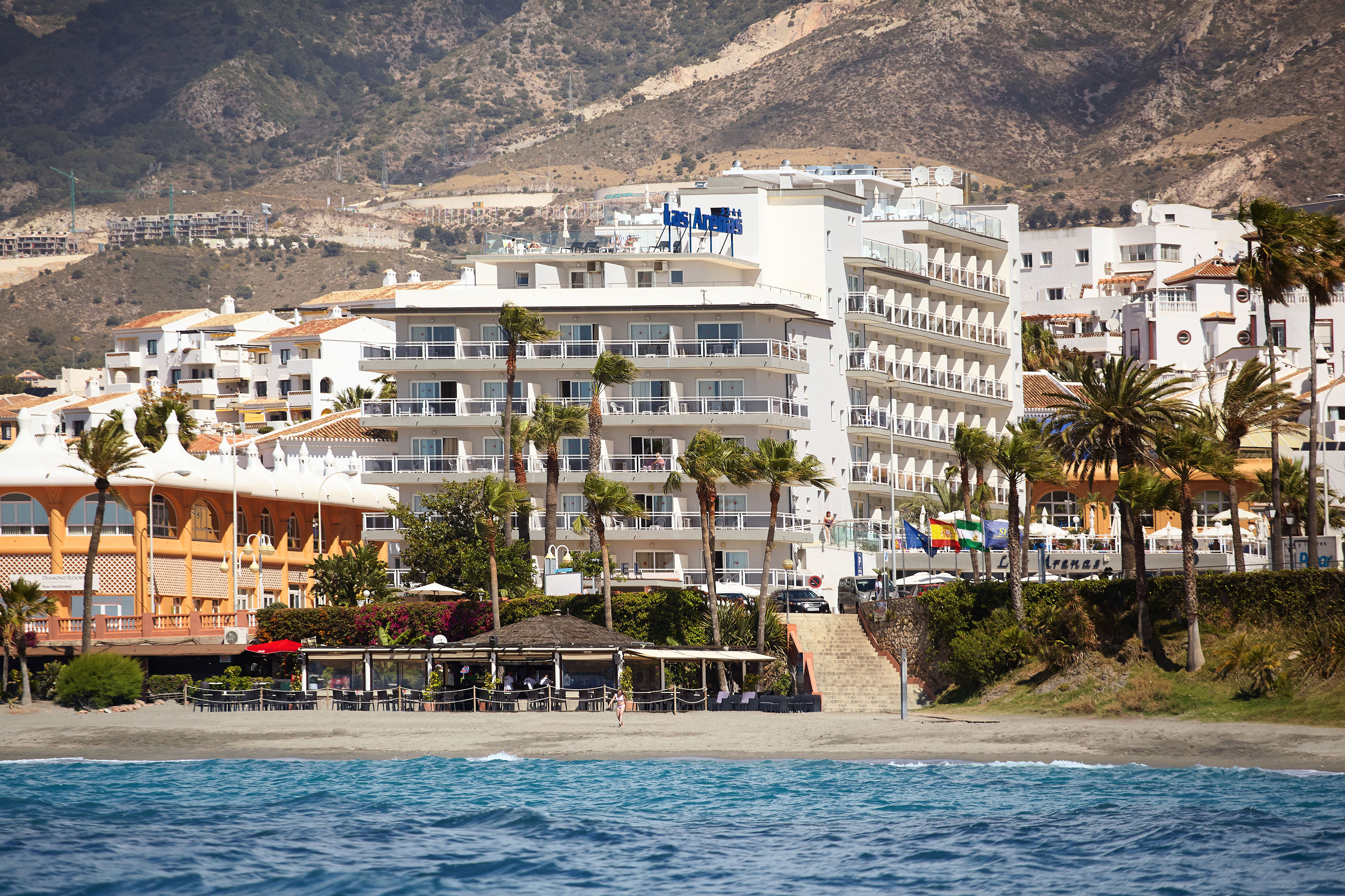 a beach with buildings and trees