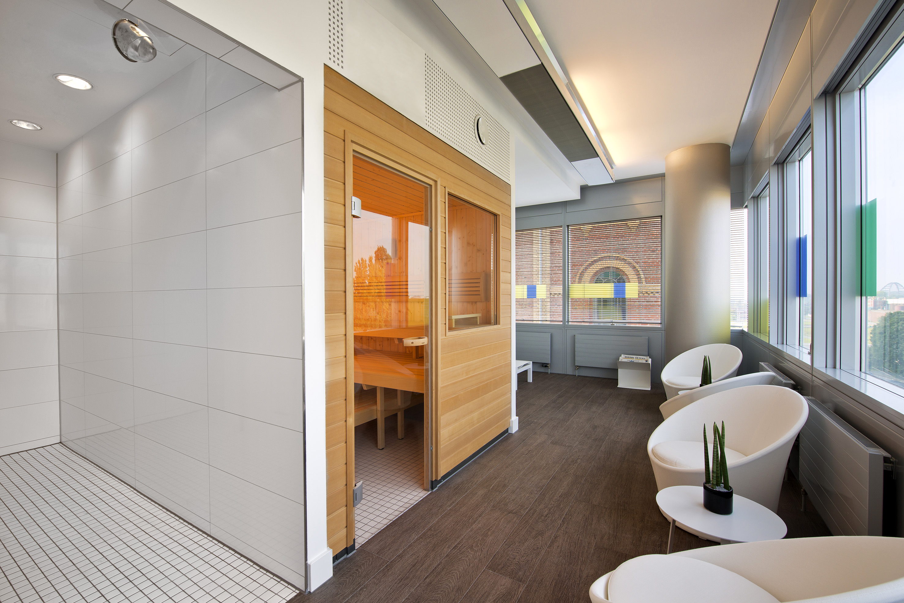 Modern spa with wooden sauna, shower, and relaxation lounge.