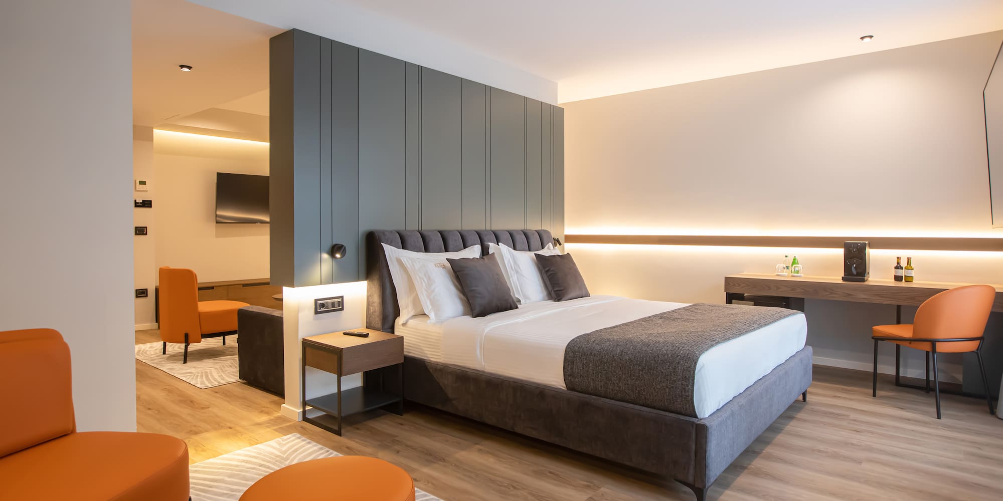 a bedroom with a bed and orange chairs