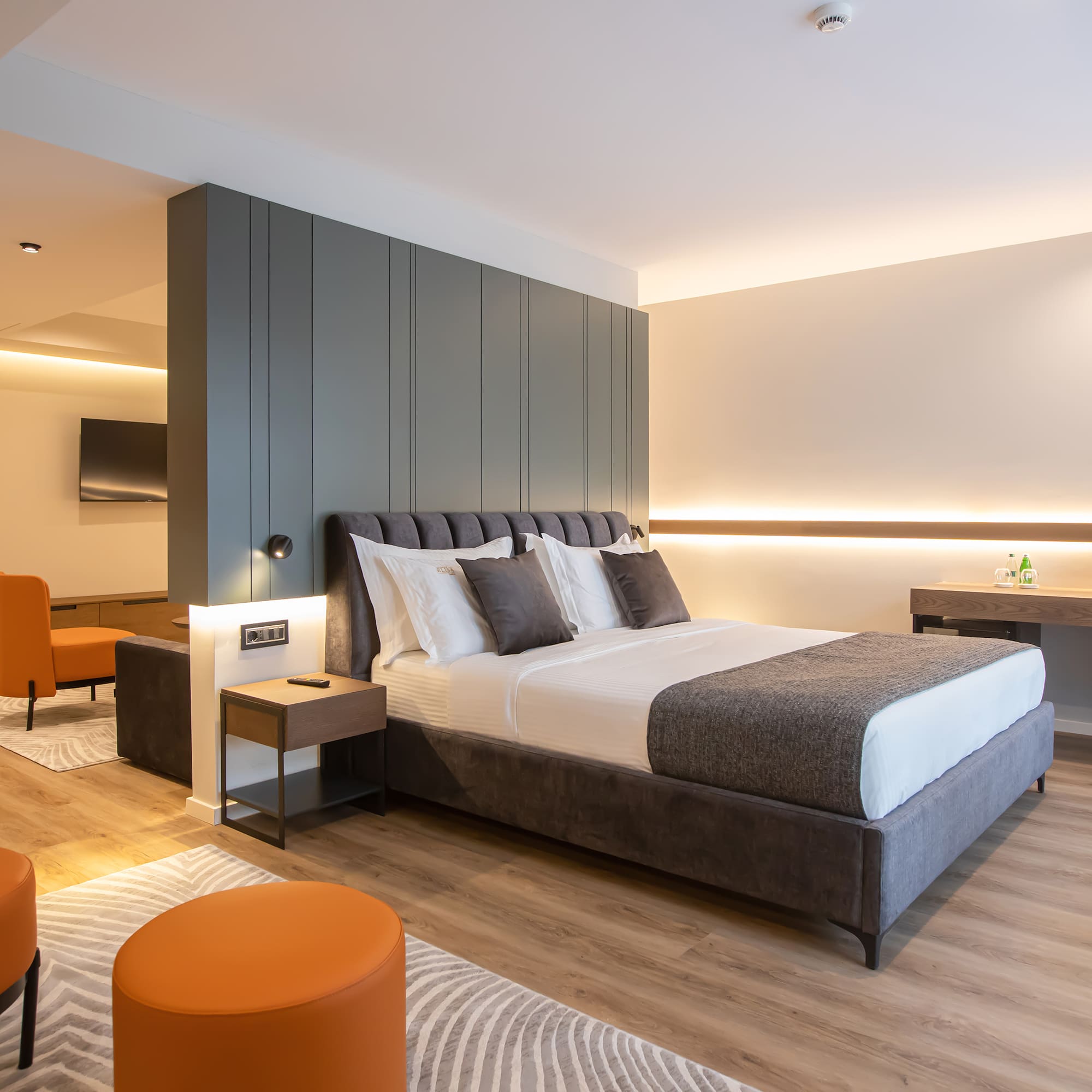 a bedroom with a bed and orange chairs