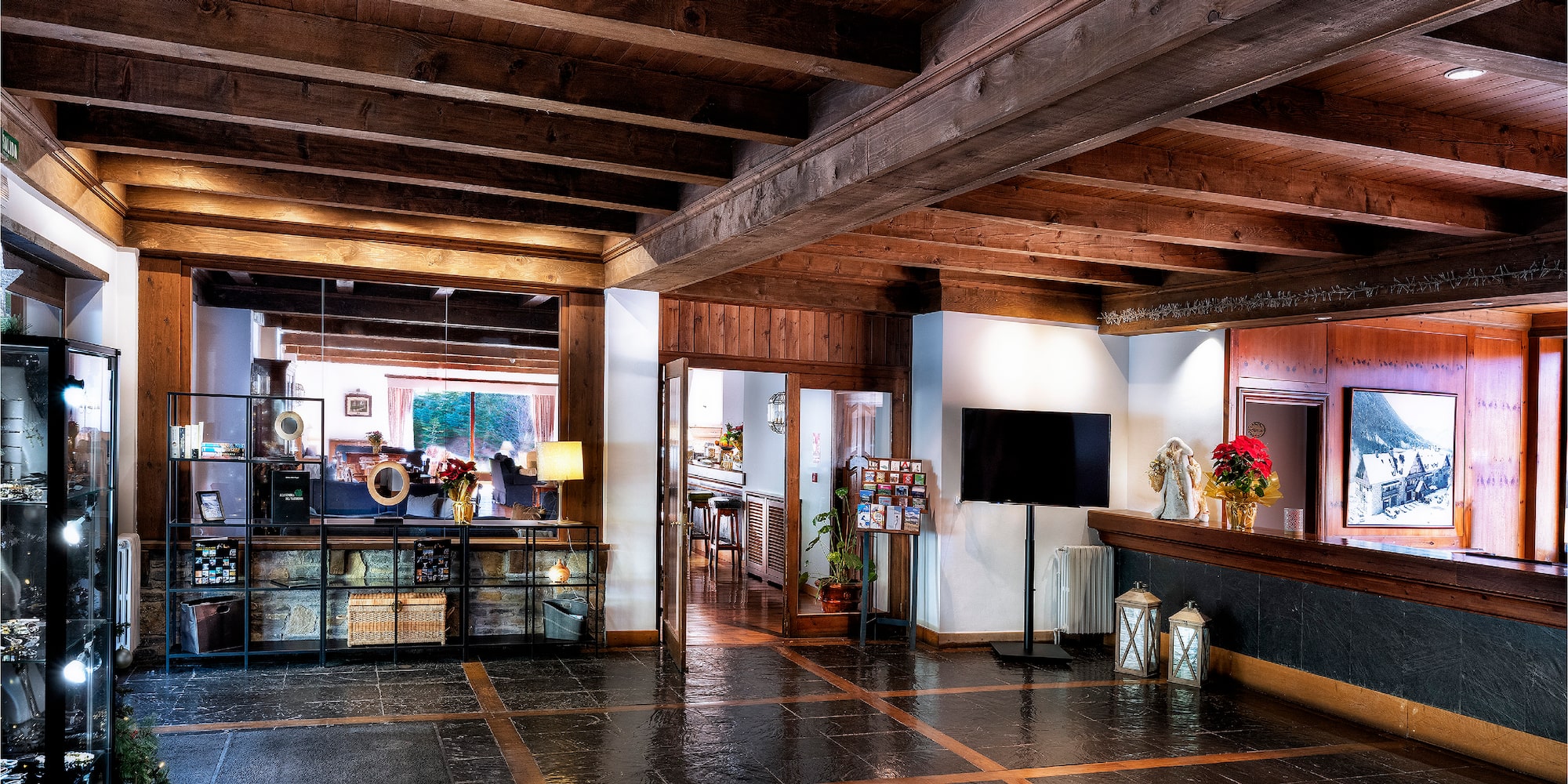 a room with a black tile floor and wood beams