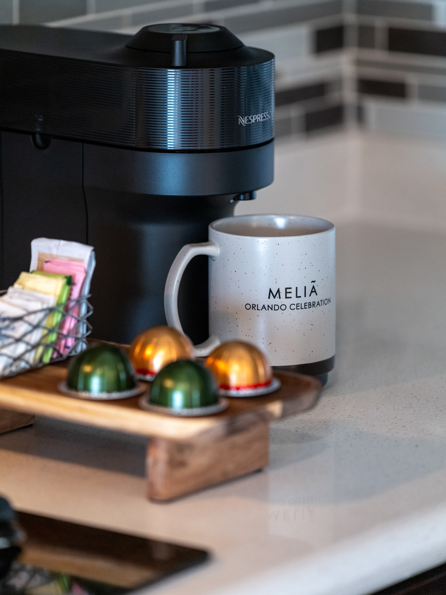 a coffee machine with a mug and some colorful capsules