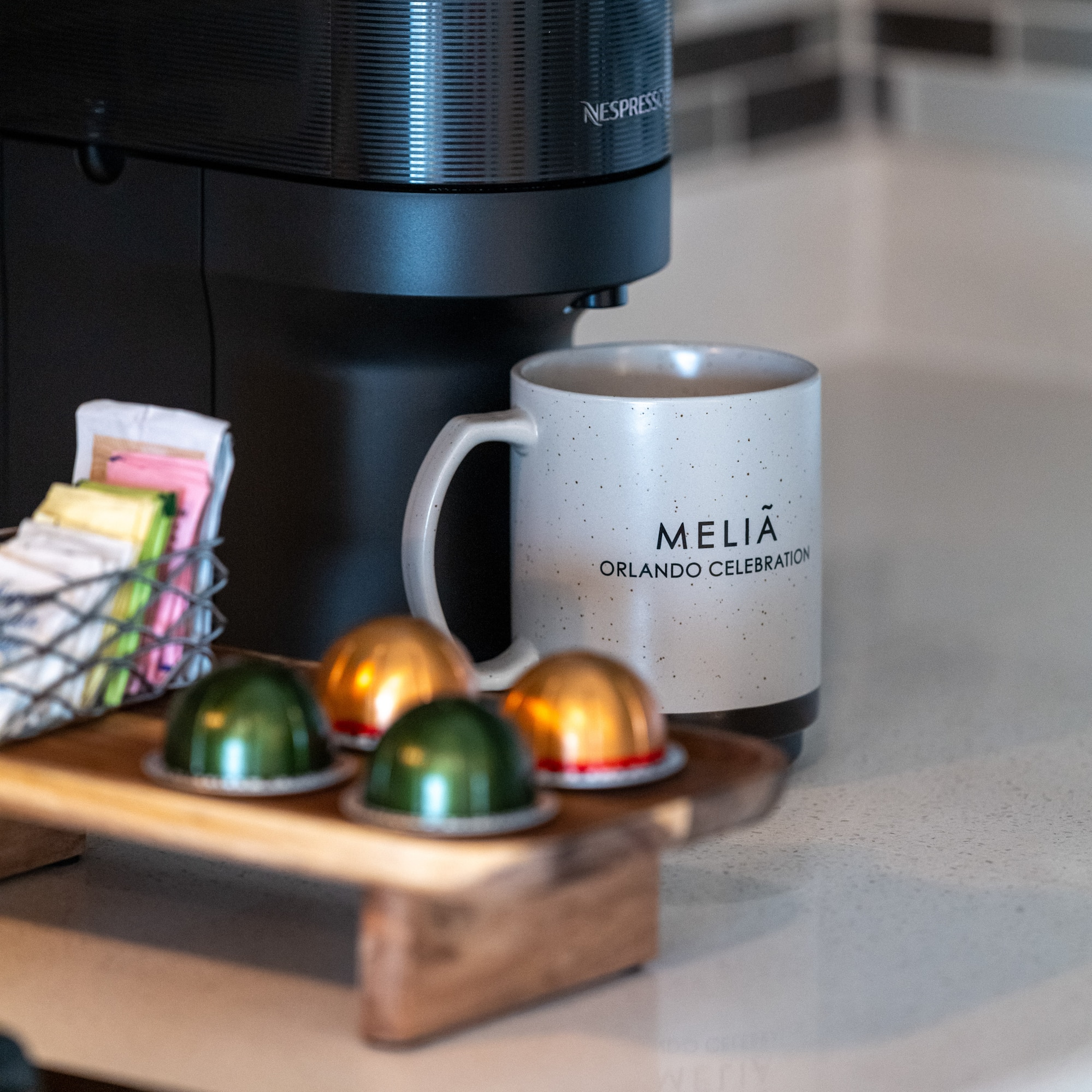 a coffee machine with a mug and some colorful capsules