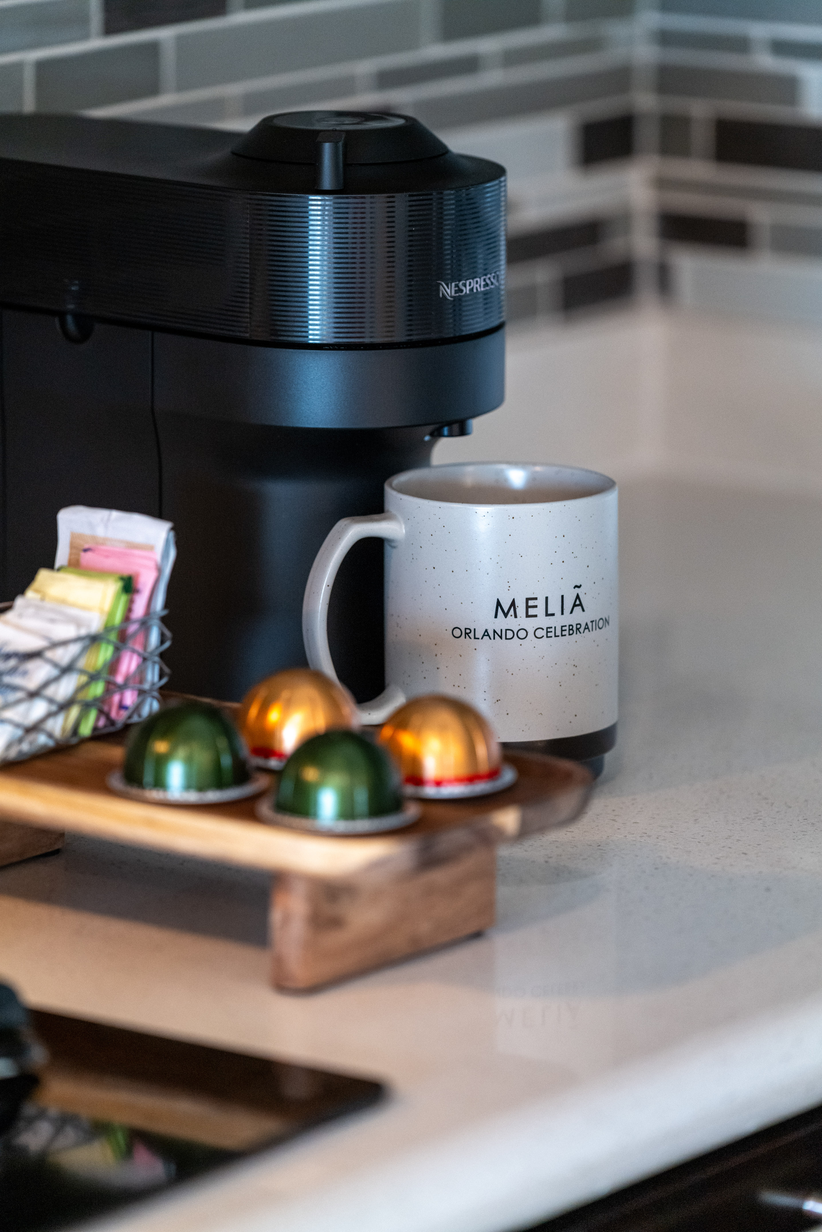Nespresso coffee station with Melia Orlando mug, pods, and sugar packets.