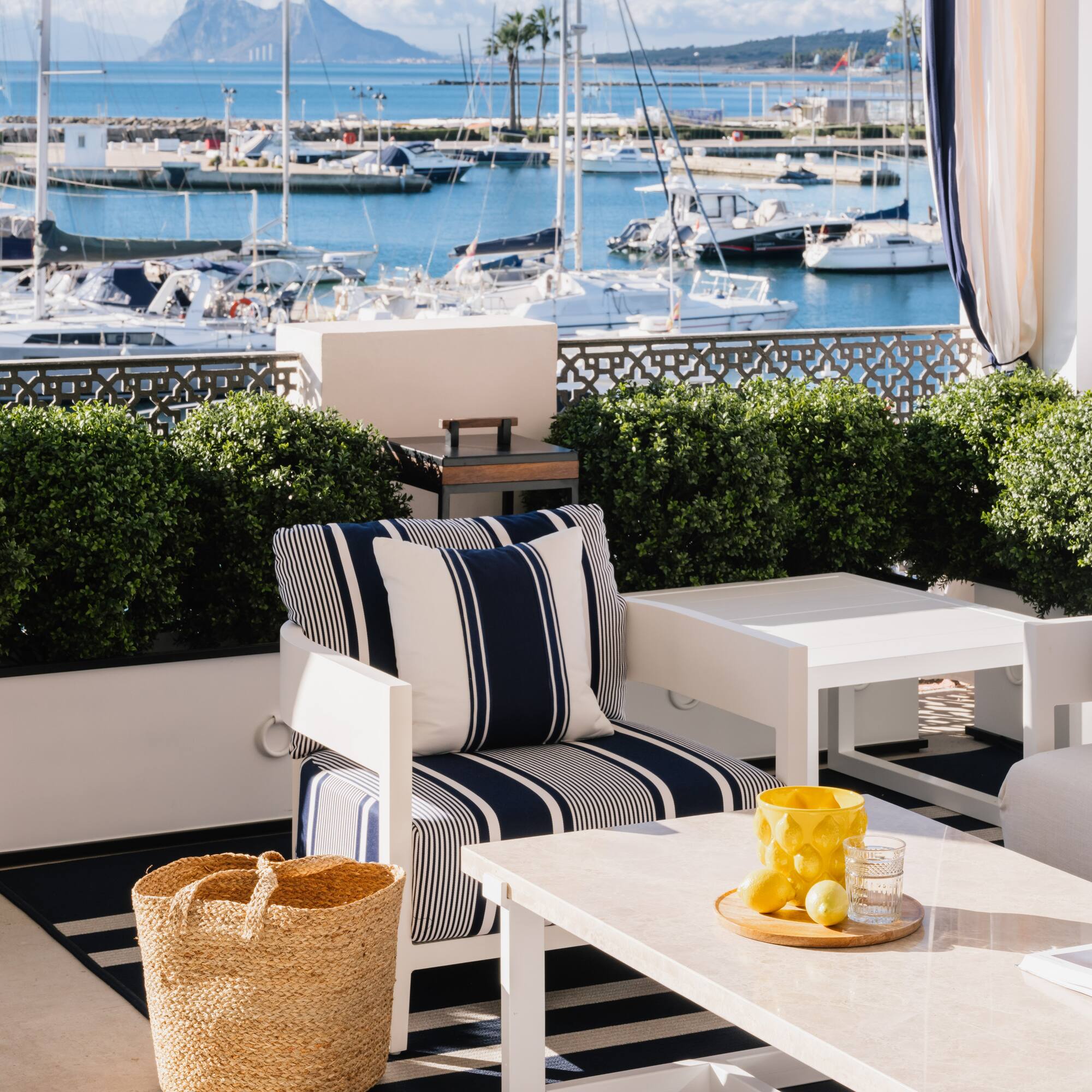 a patio with a view of boats and a mountain in the background