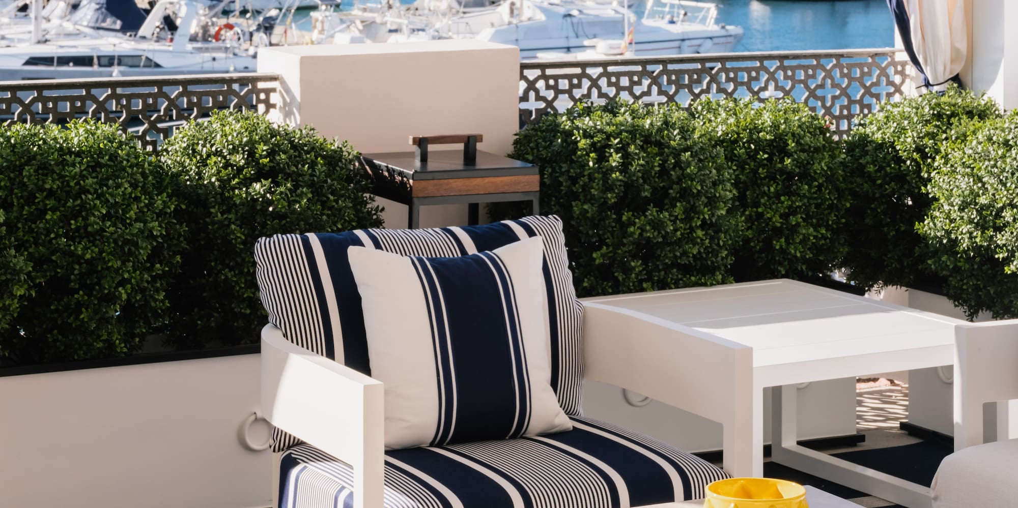 a patio with a view of boats and a mountain in the background