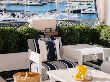 a patio with a view of boats and a mountain in the background