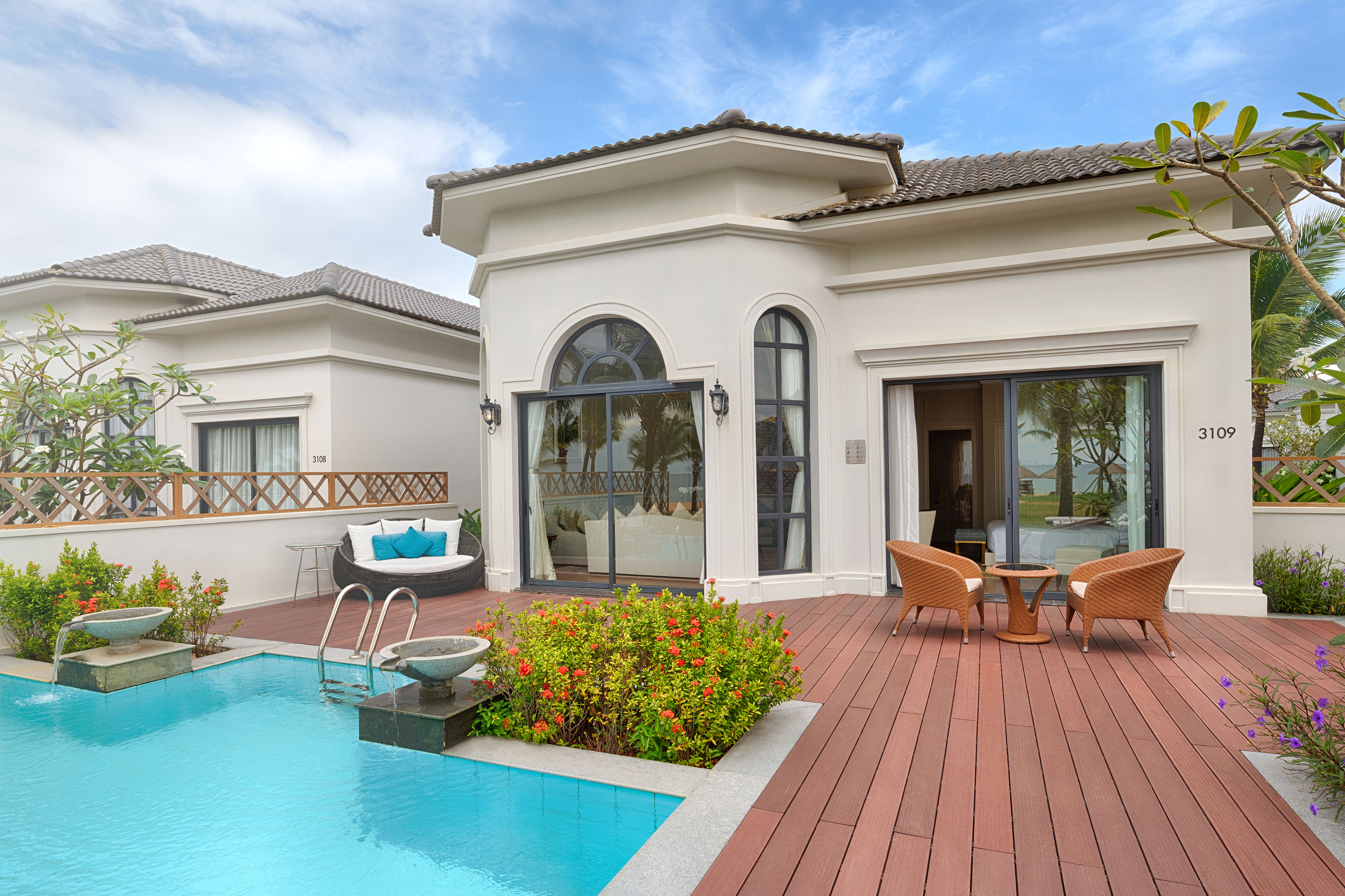 Resort villa exterior with private pool, wooden deck, and outdoor seating.