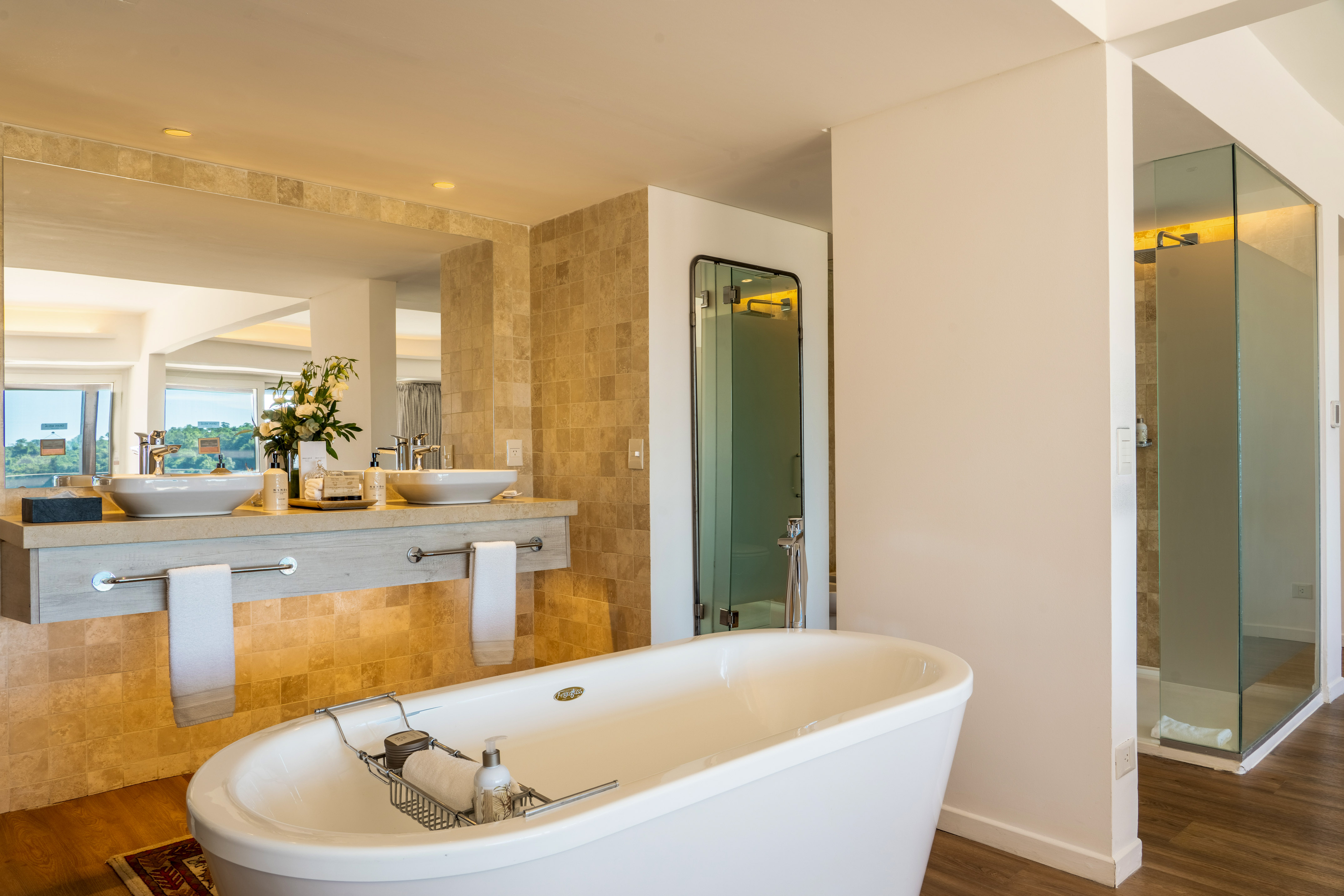 Modern luxury bathroom with freestanding tub, double vanity, and glass shower.
