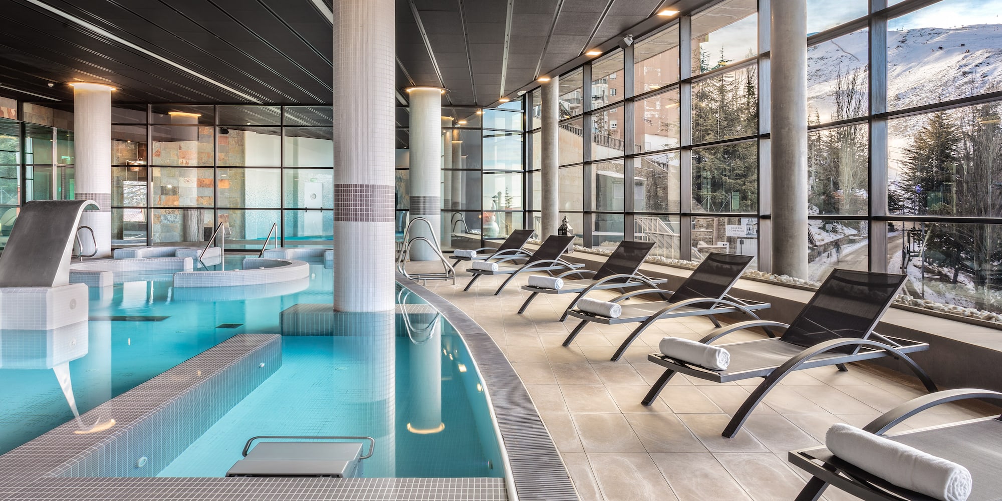a pool with chairs and a large window