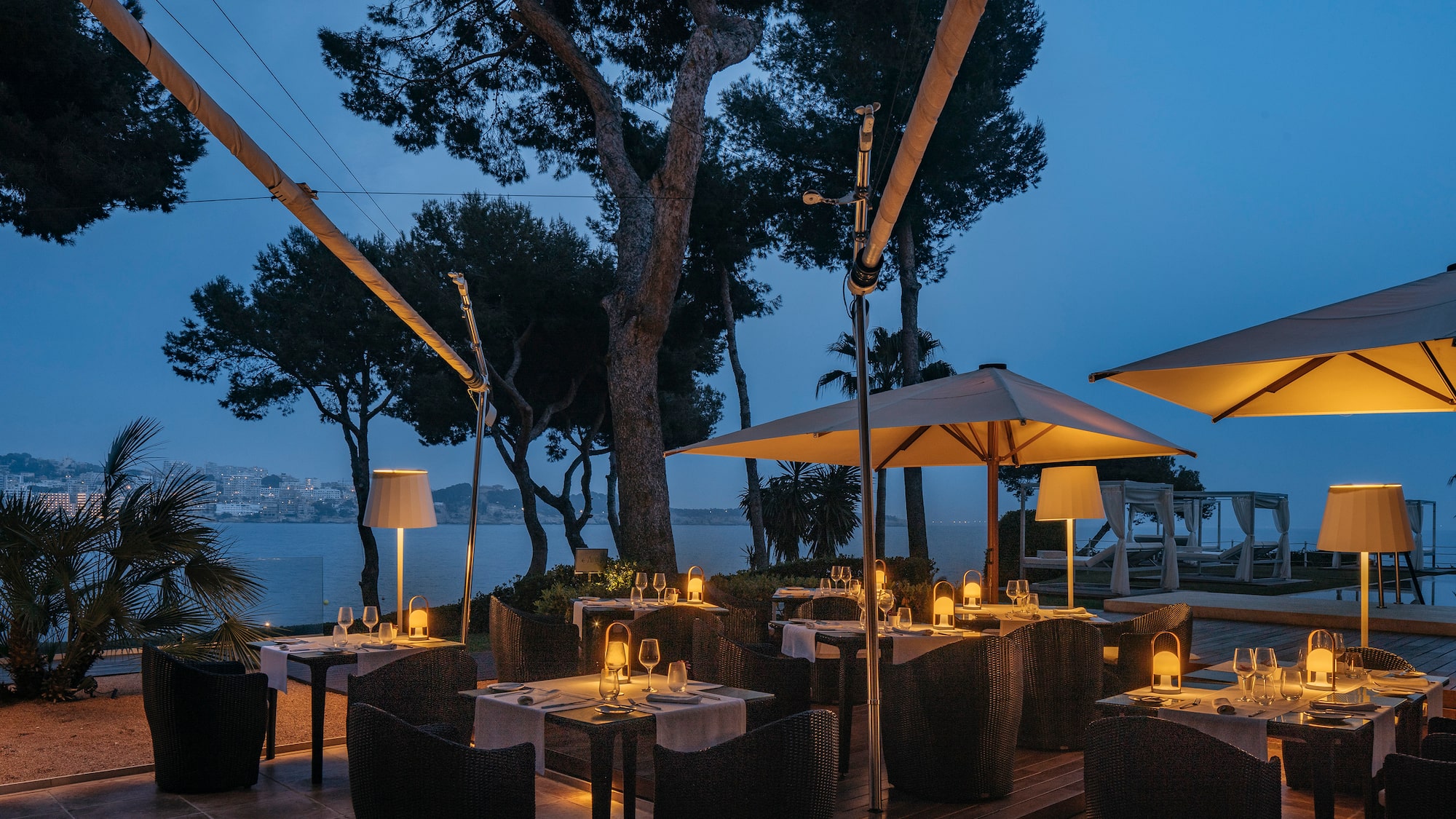 a table with candles and umbrellas on a patio
