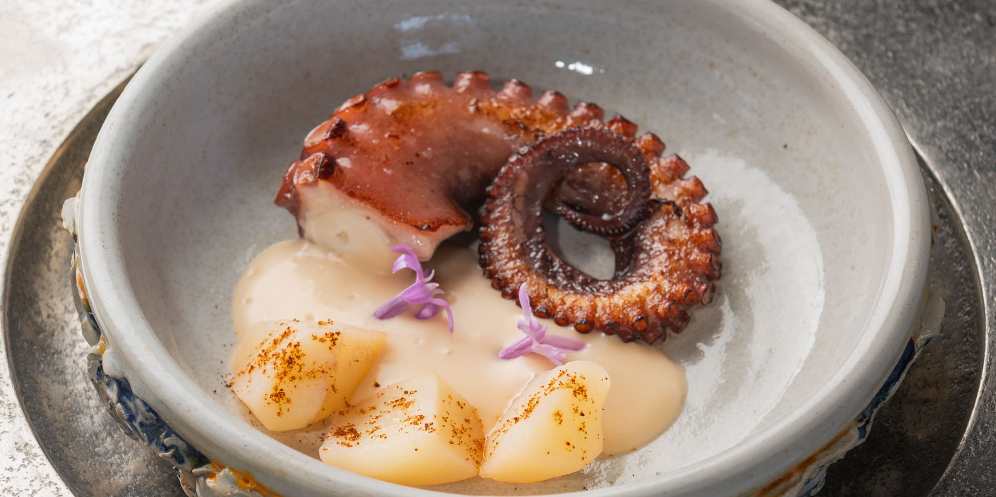 Gourmet grilled octopus and scallops with creamy sauce.