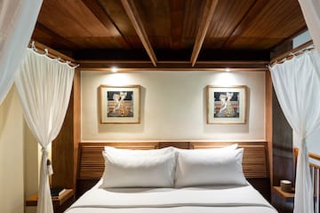 a bed with white pillows and a wood headboard