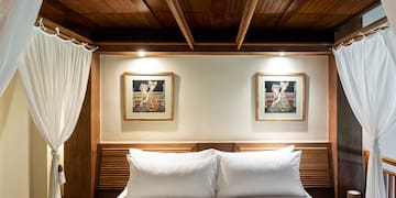 a bed with white pillows and a wood headboard