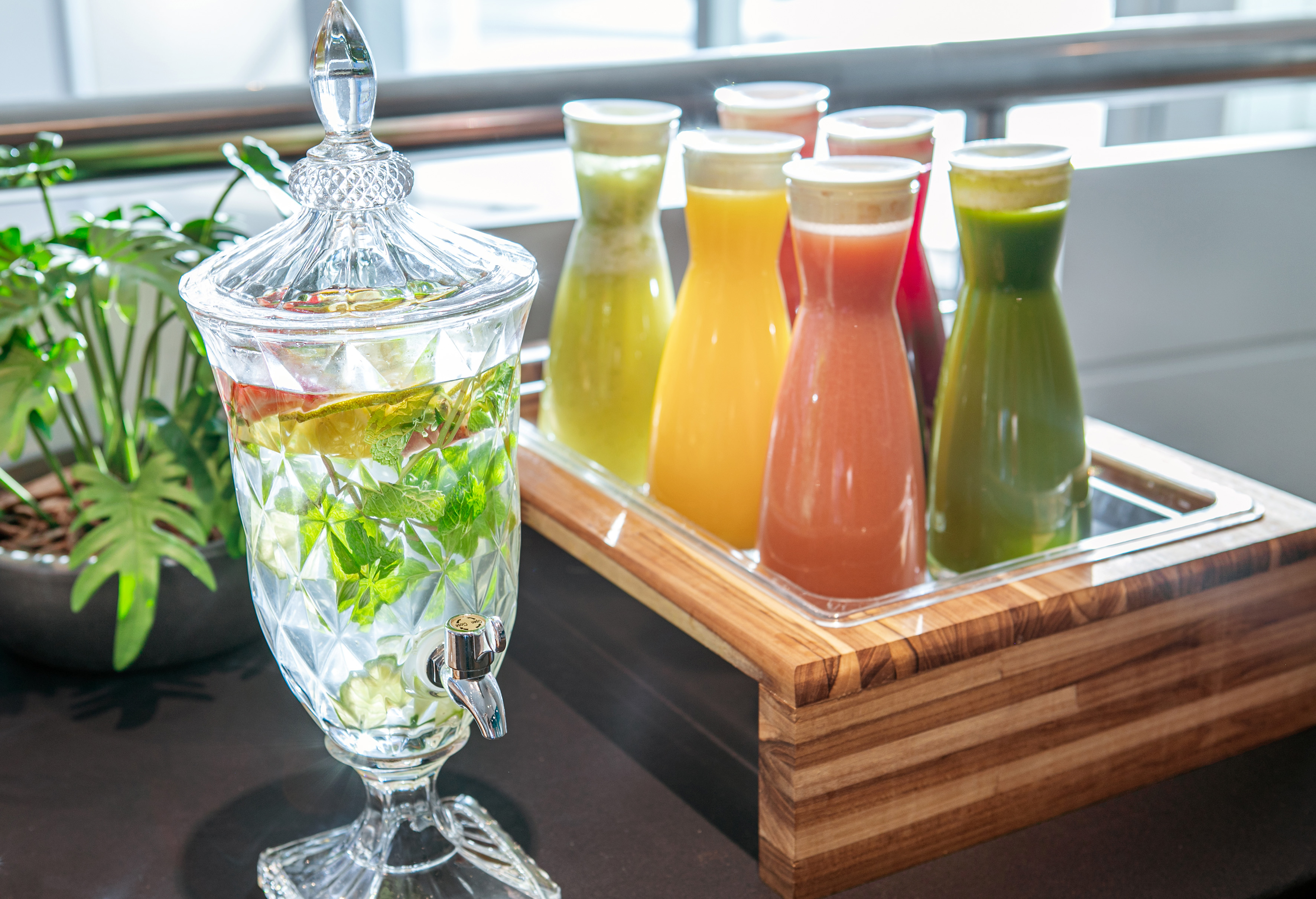Healthy infused water and fresh fruit juices at a breakfast buffet.