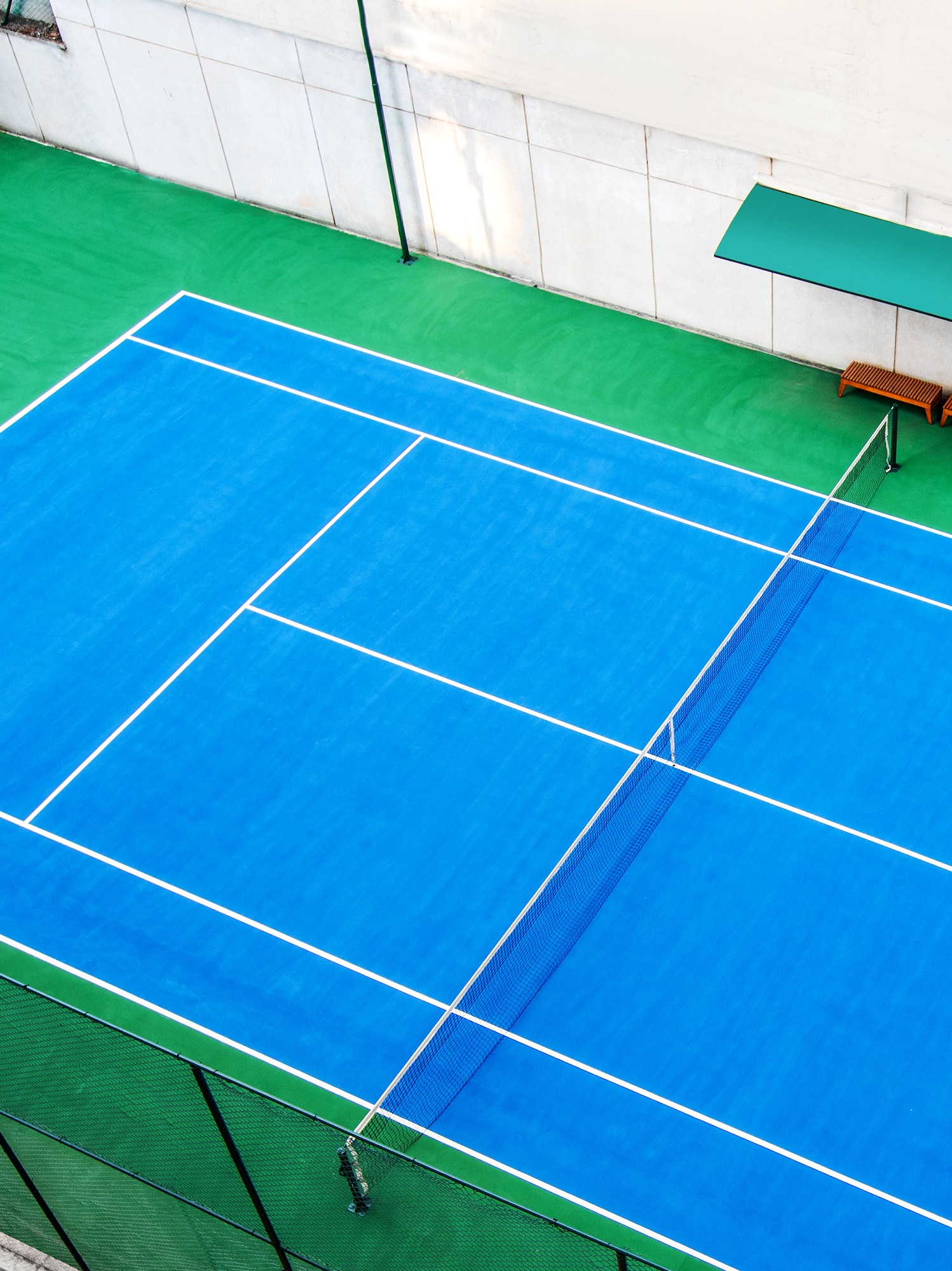 a tennis court with a bench and a bench