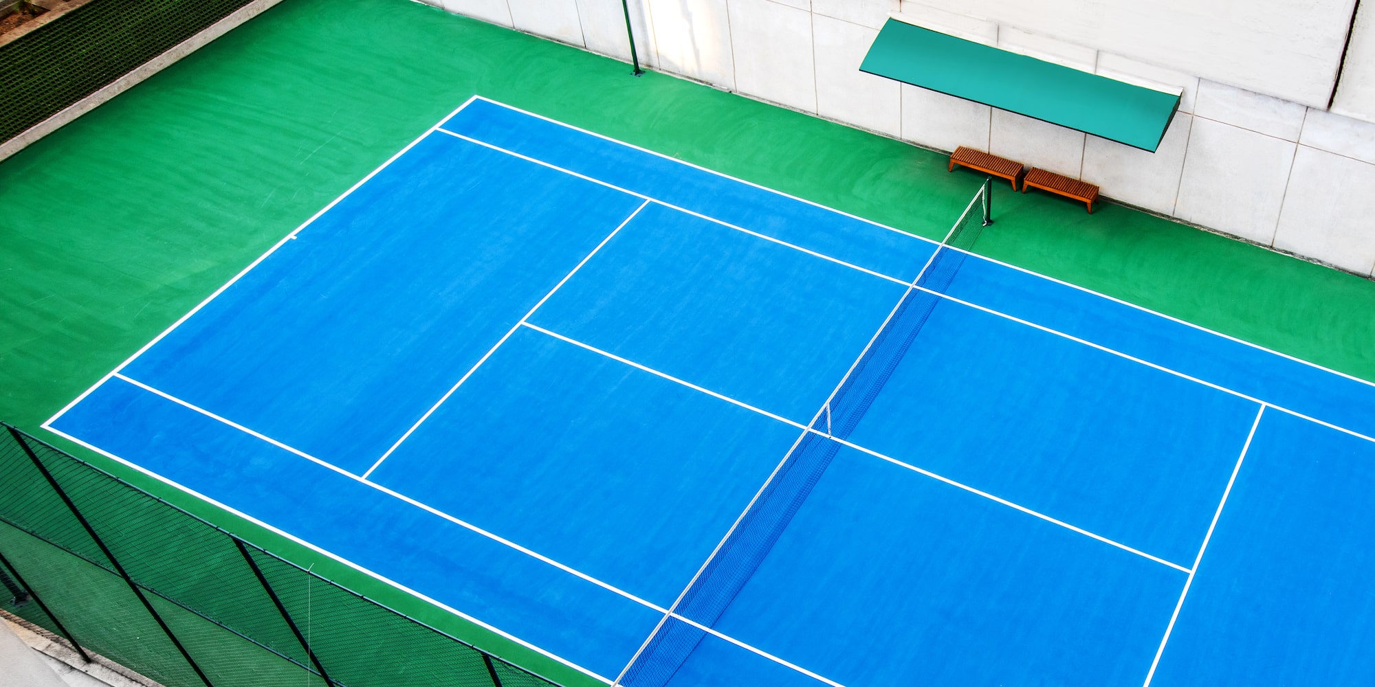 a tennis court with a bench and a bench