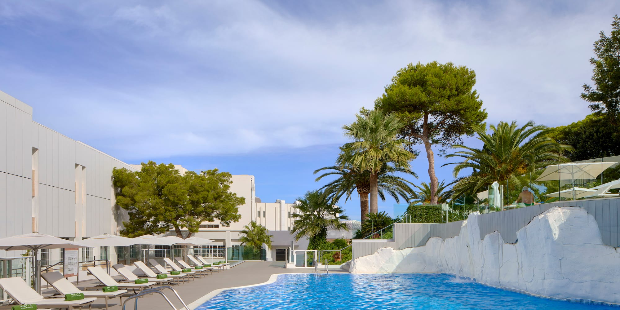 a pool with chairs and trees in the background