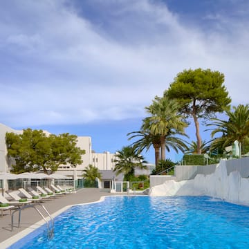 a pool with chairs and trees in the background