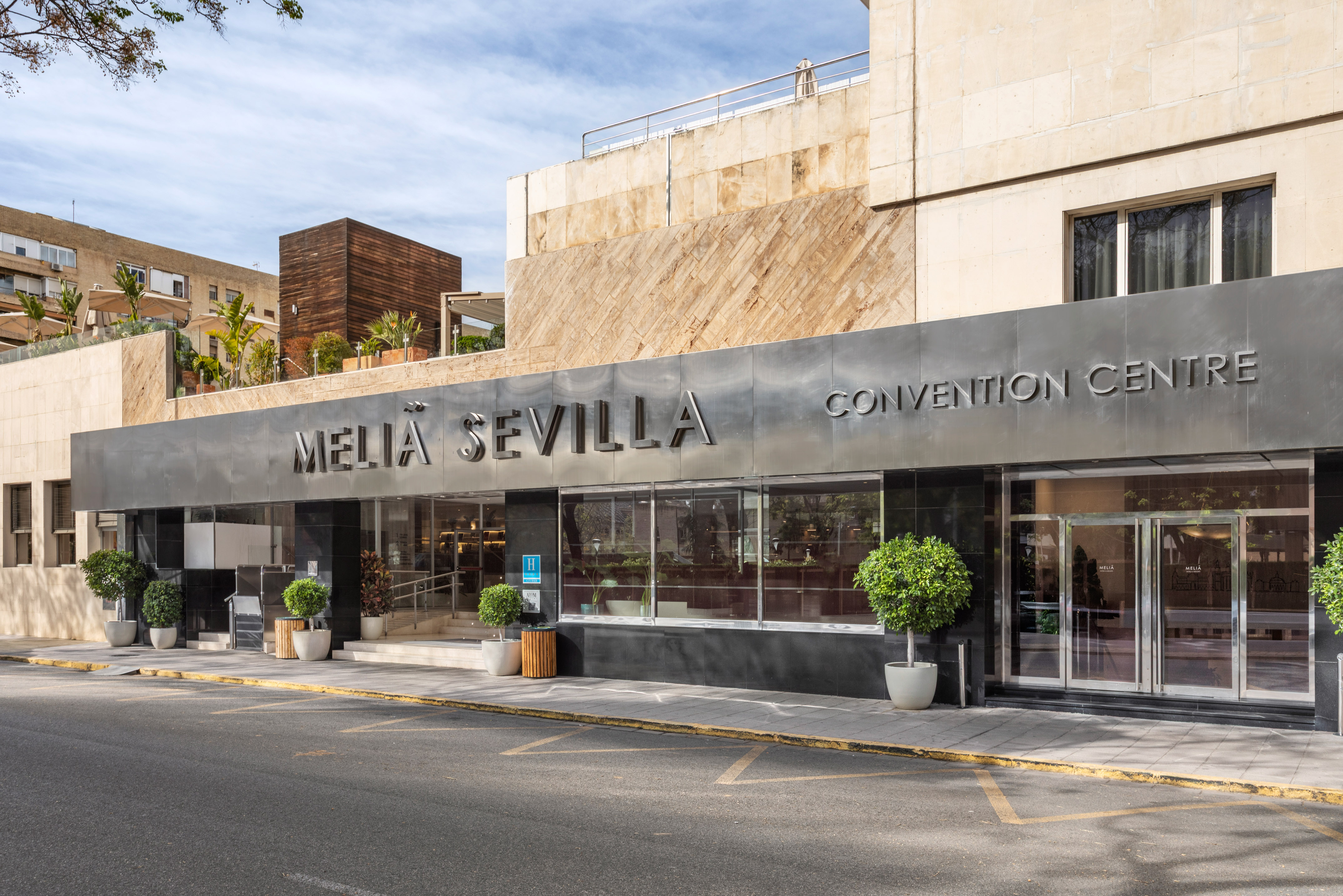 Melia Sevilla Hotel & Convention Centre entrance with potted trees.