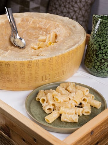 a wheel of cheese and pasta on a plate