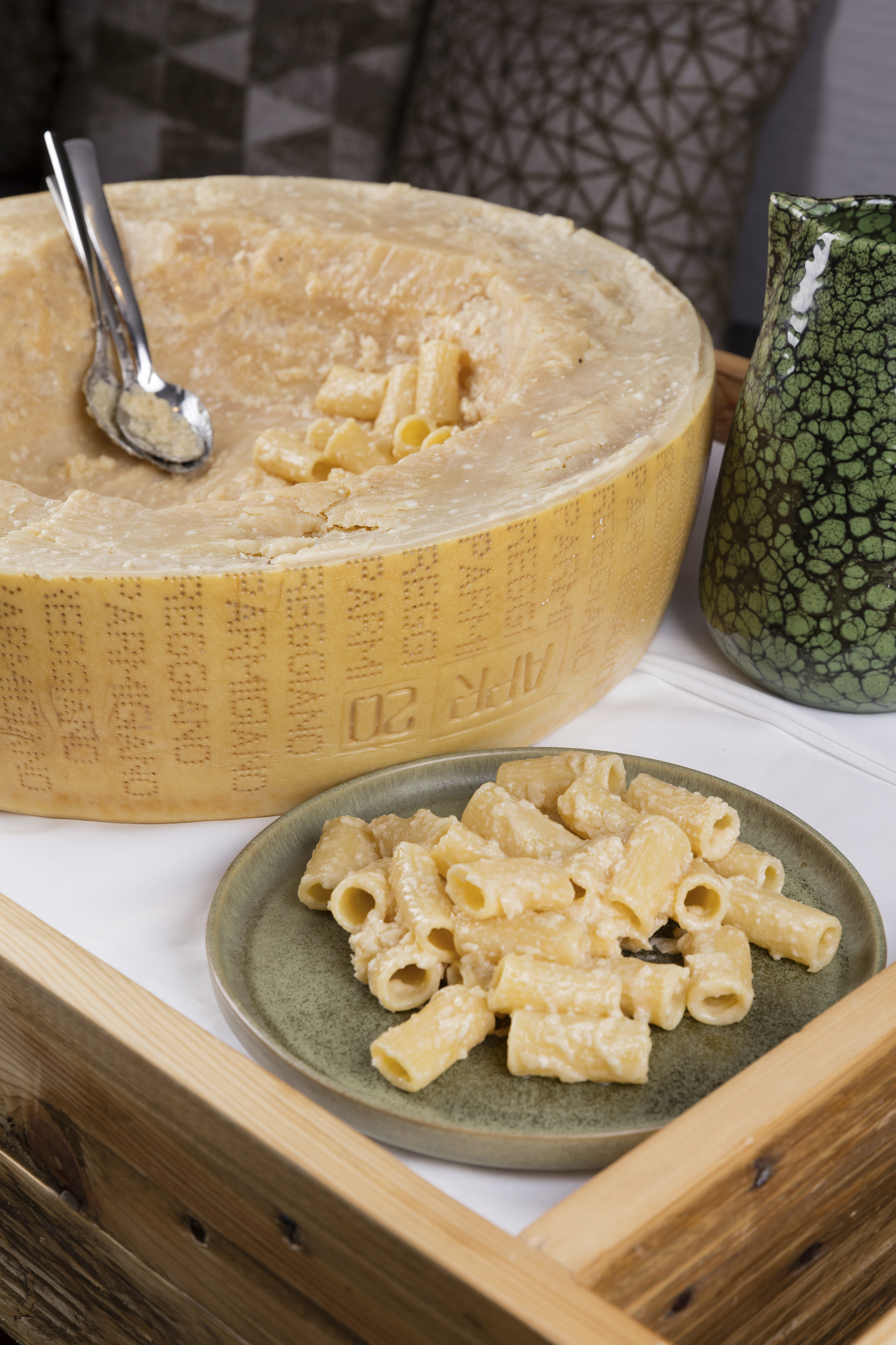Rigatoni pasta served from a large Parmigiano Reggiano cheese wheel.