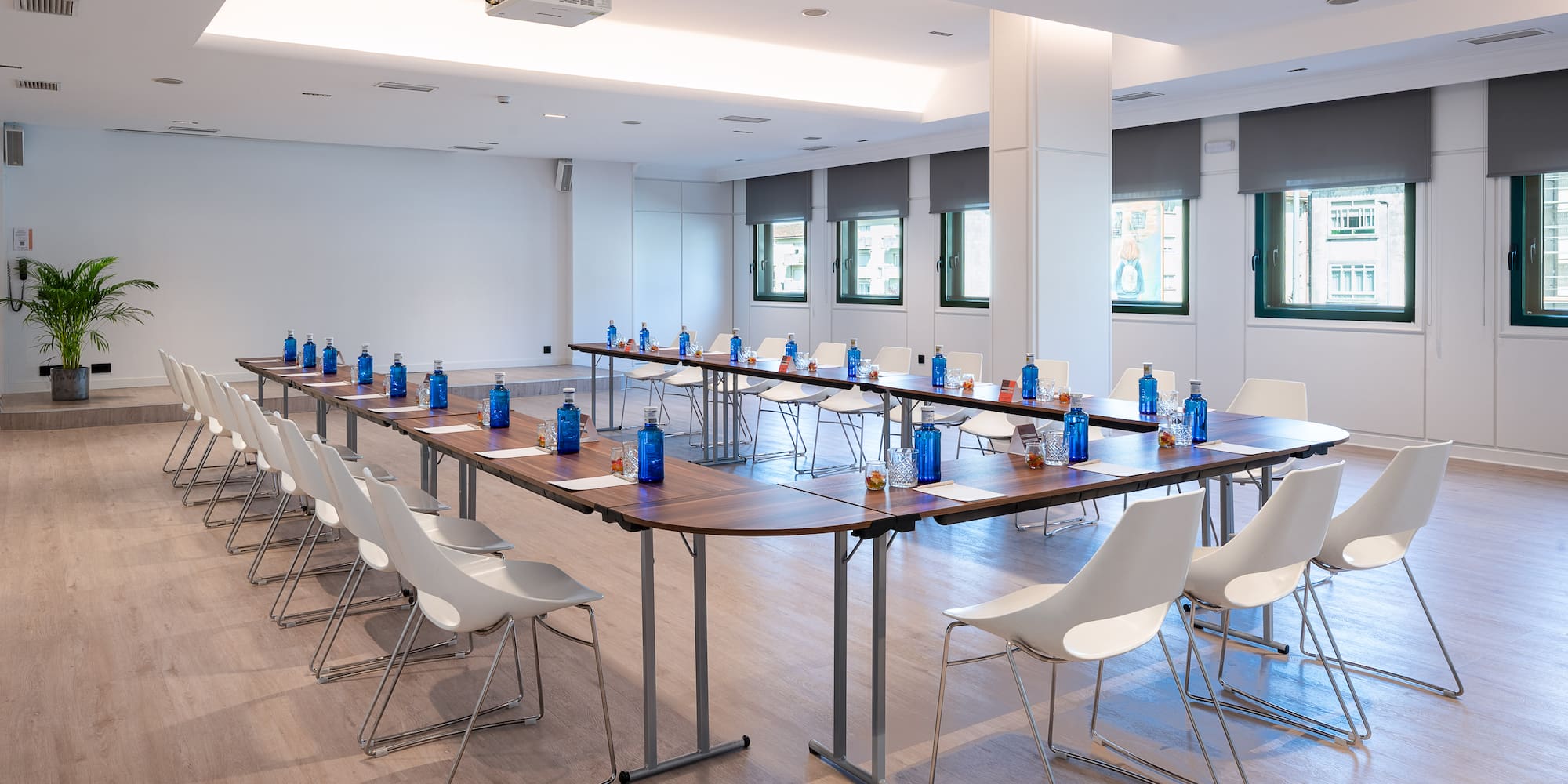 a room with a long table with chairs and a table with water bottles