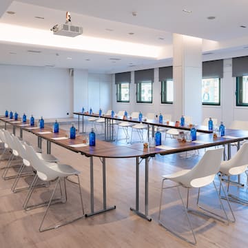 a room with a long table with chairs and a table with water bottles
