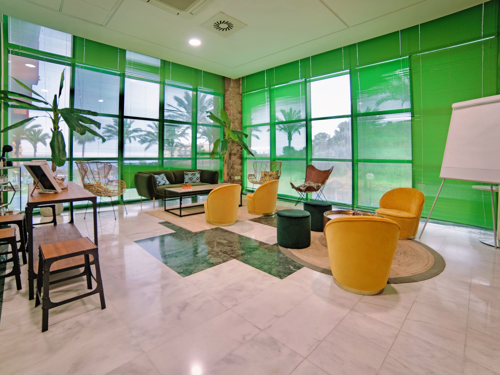 a room with green walls and a green wall with a green wall and a green couch and chairs