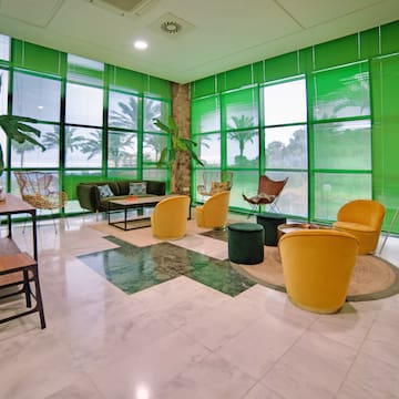 a room with green walls and a green wall with a green wall and a green couch and chairs