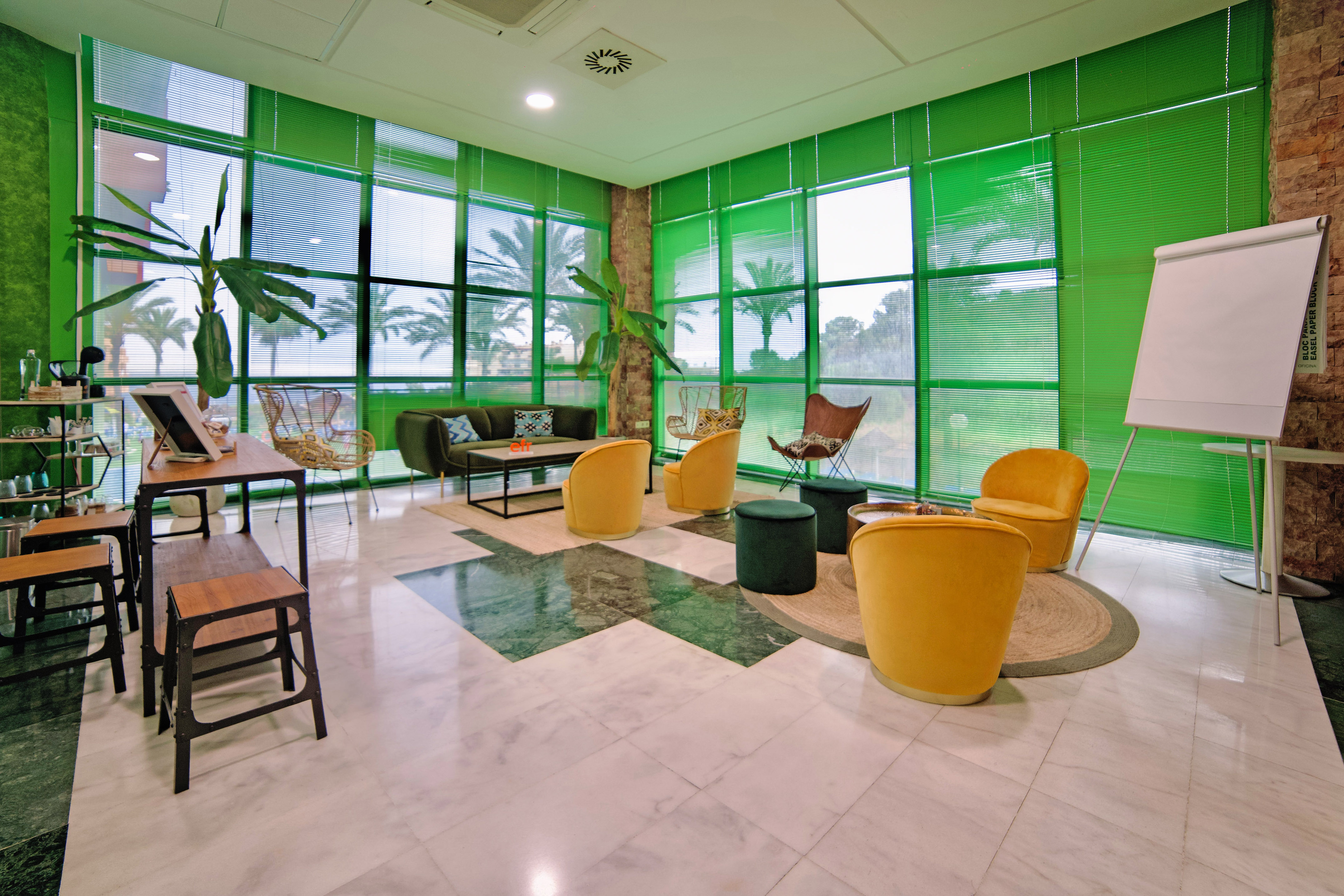 Vibrant green and yellow modern lounge with tropical plants and views.
