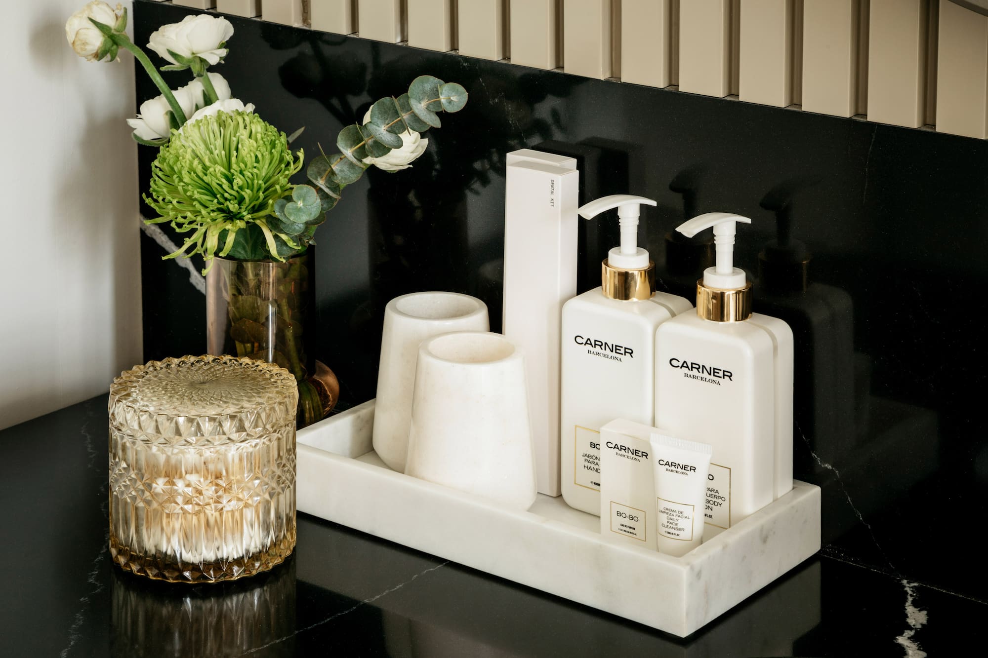 a group of white bottles and cups on a black counter