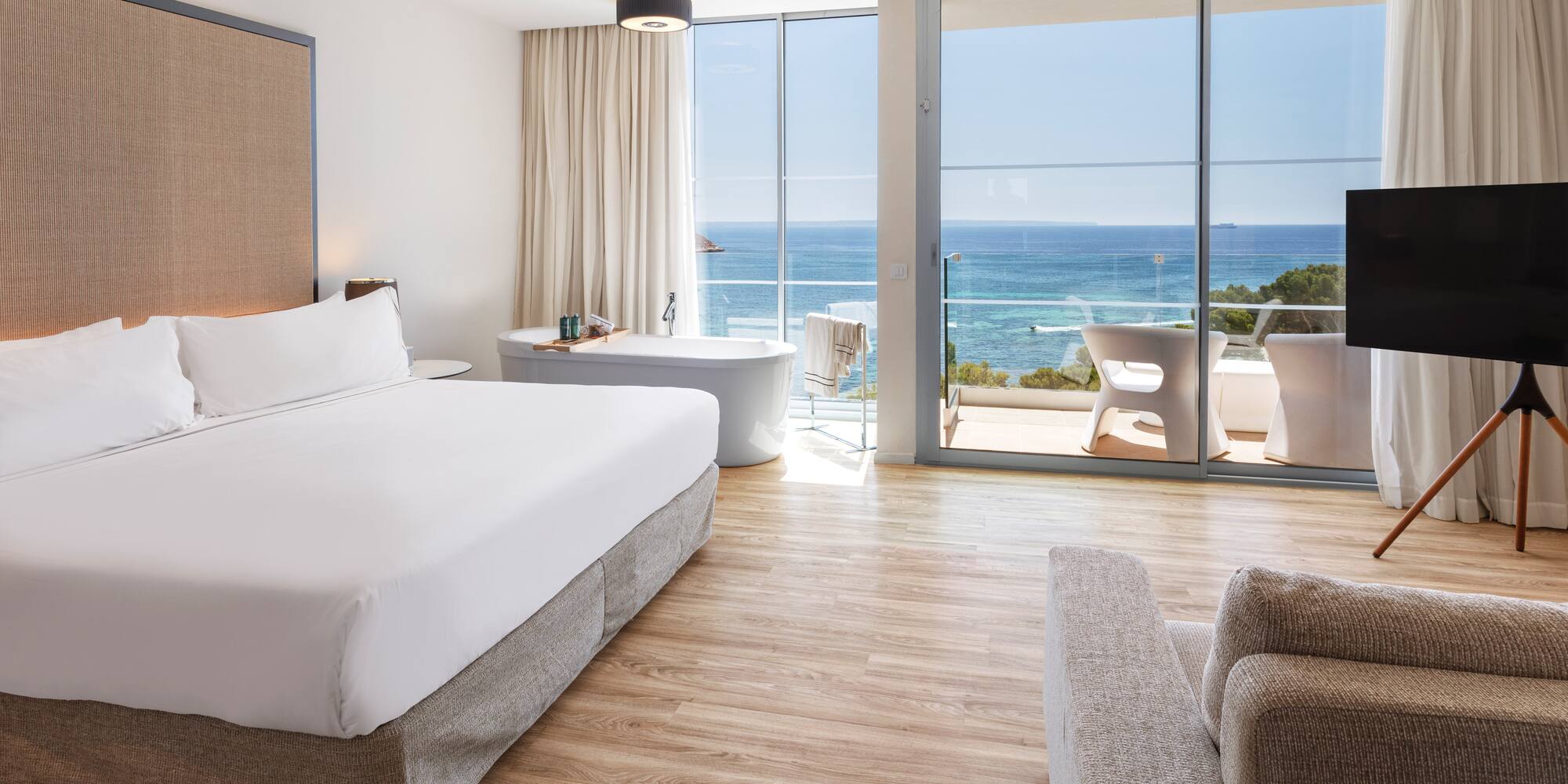 a bedroom with a large window overlooking the ocean