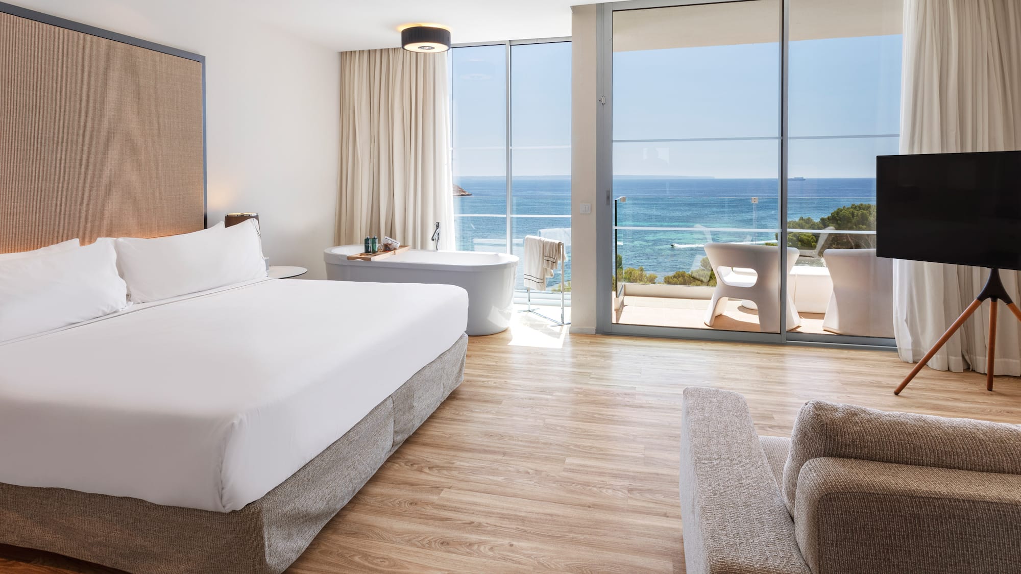 a bedroom with a large window overlooking the ocean