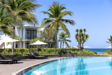 a swimming pool with palm trees and a building