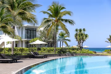 a swimming pool with palm trees and a building