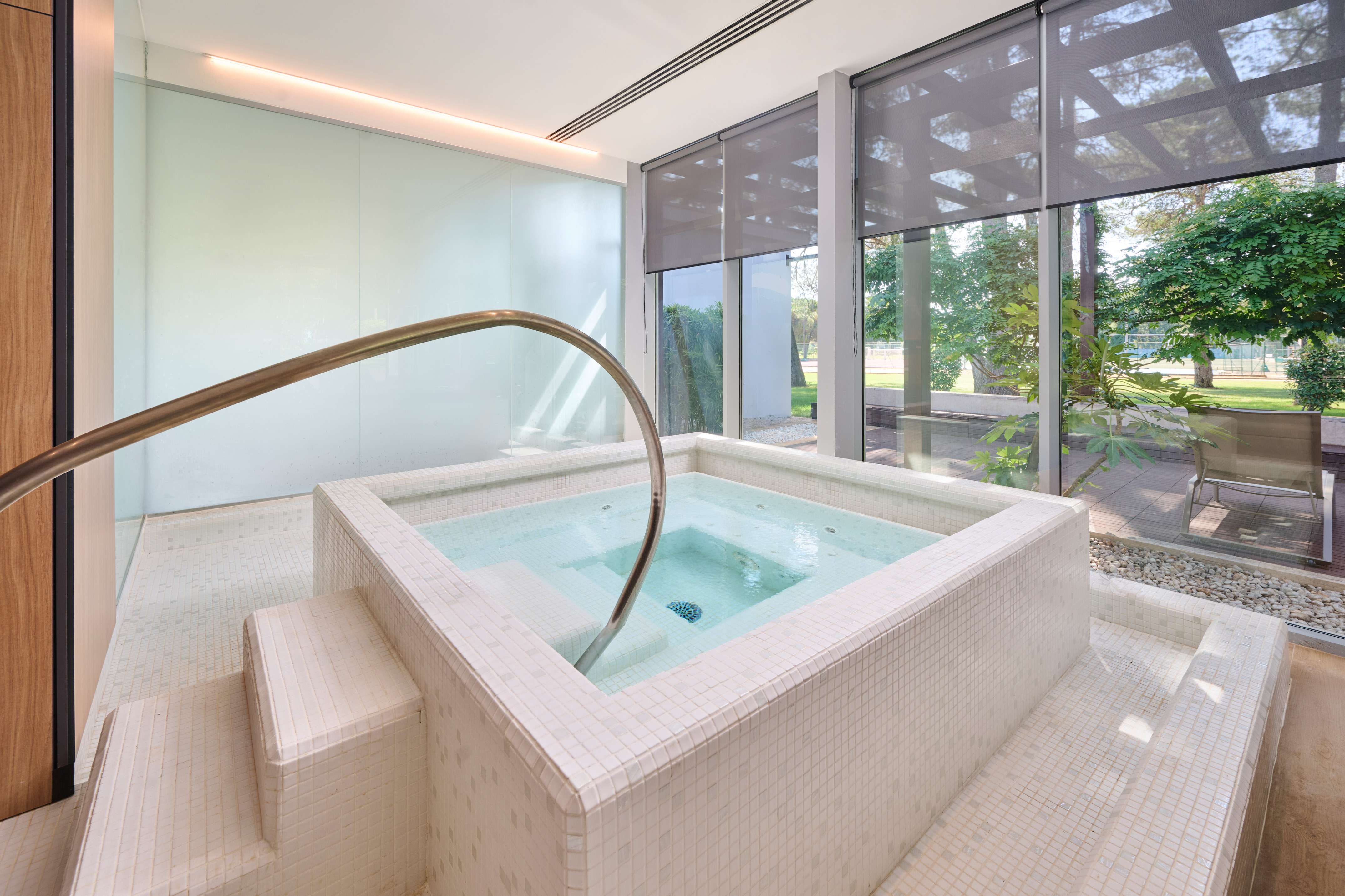 a jacuzzi with a staircase in a room with windows