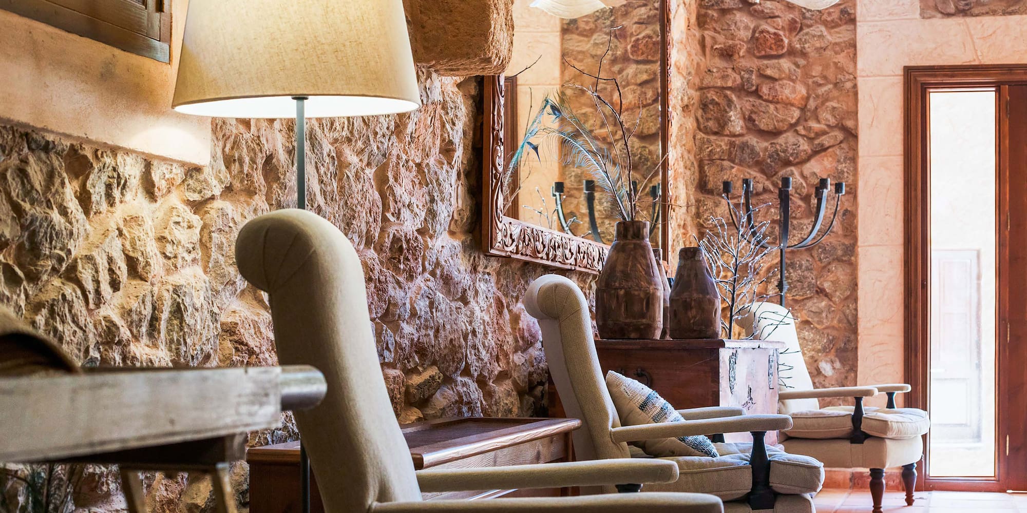 a room with a stone wall and chairs