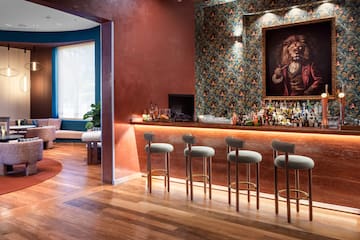 a bar with stools and a painting of a lion