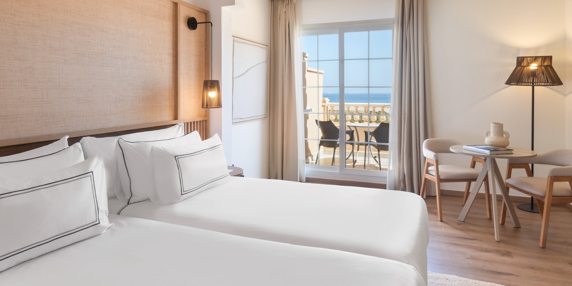 a room with two beds and a table and chairs