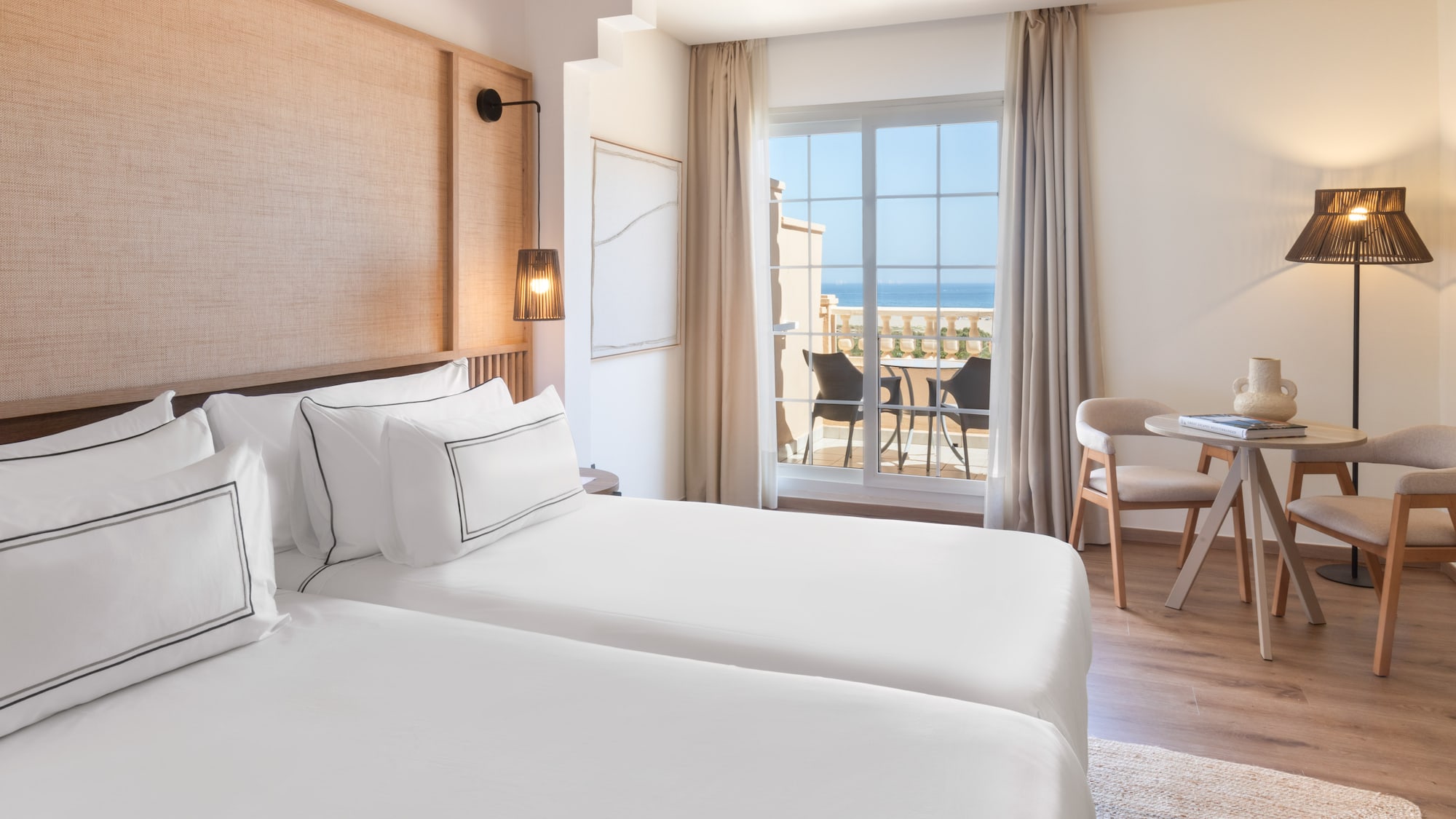 a room with two beds and a table and chairs