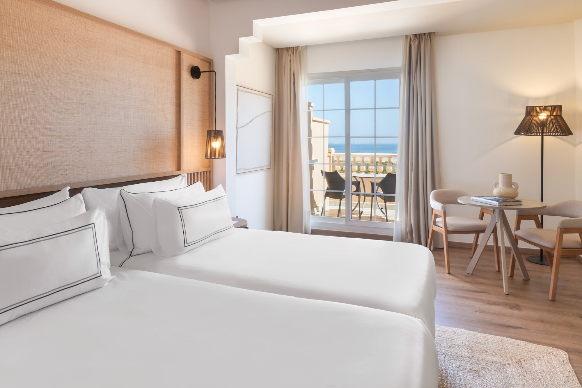 a room with two beds and a table and chairs