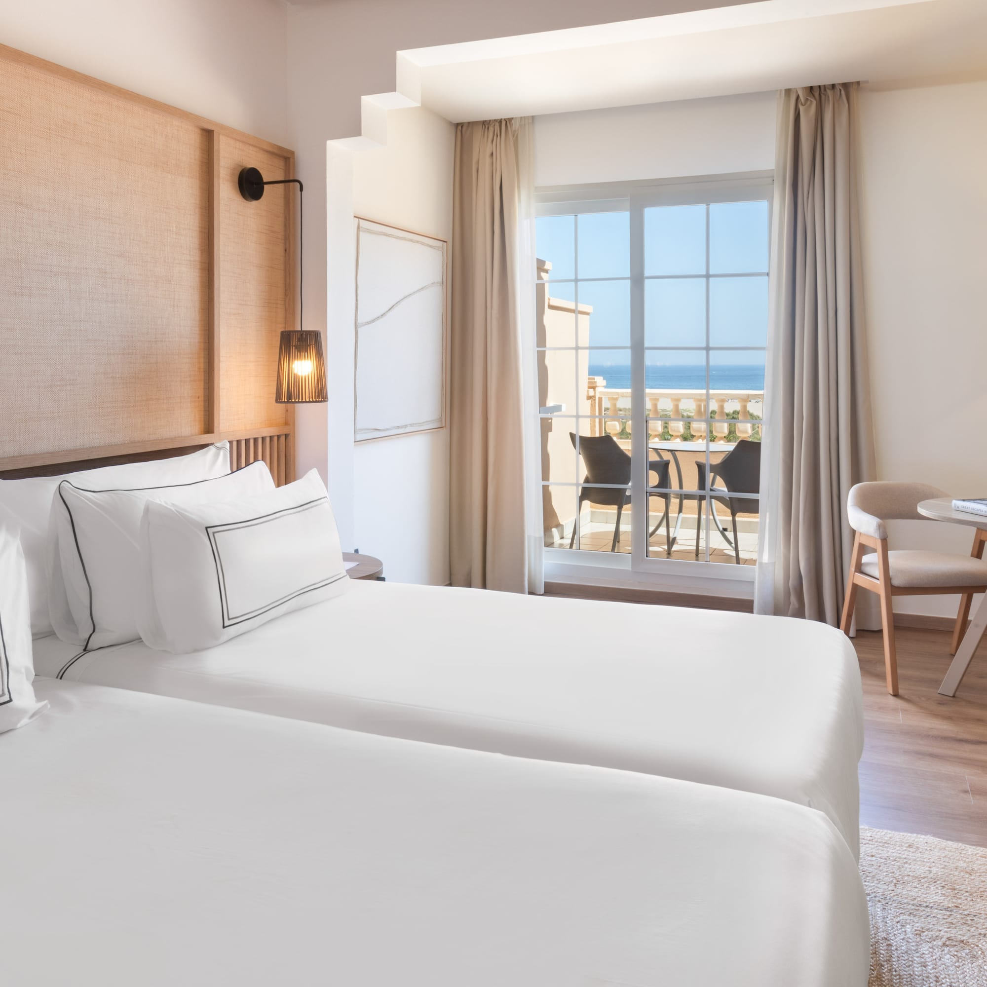 a room with two beds and a table and chairs