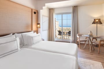 a room with two beds and a table and chairs