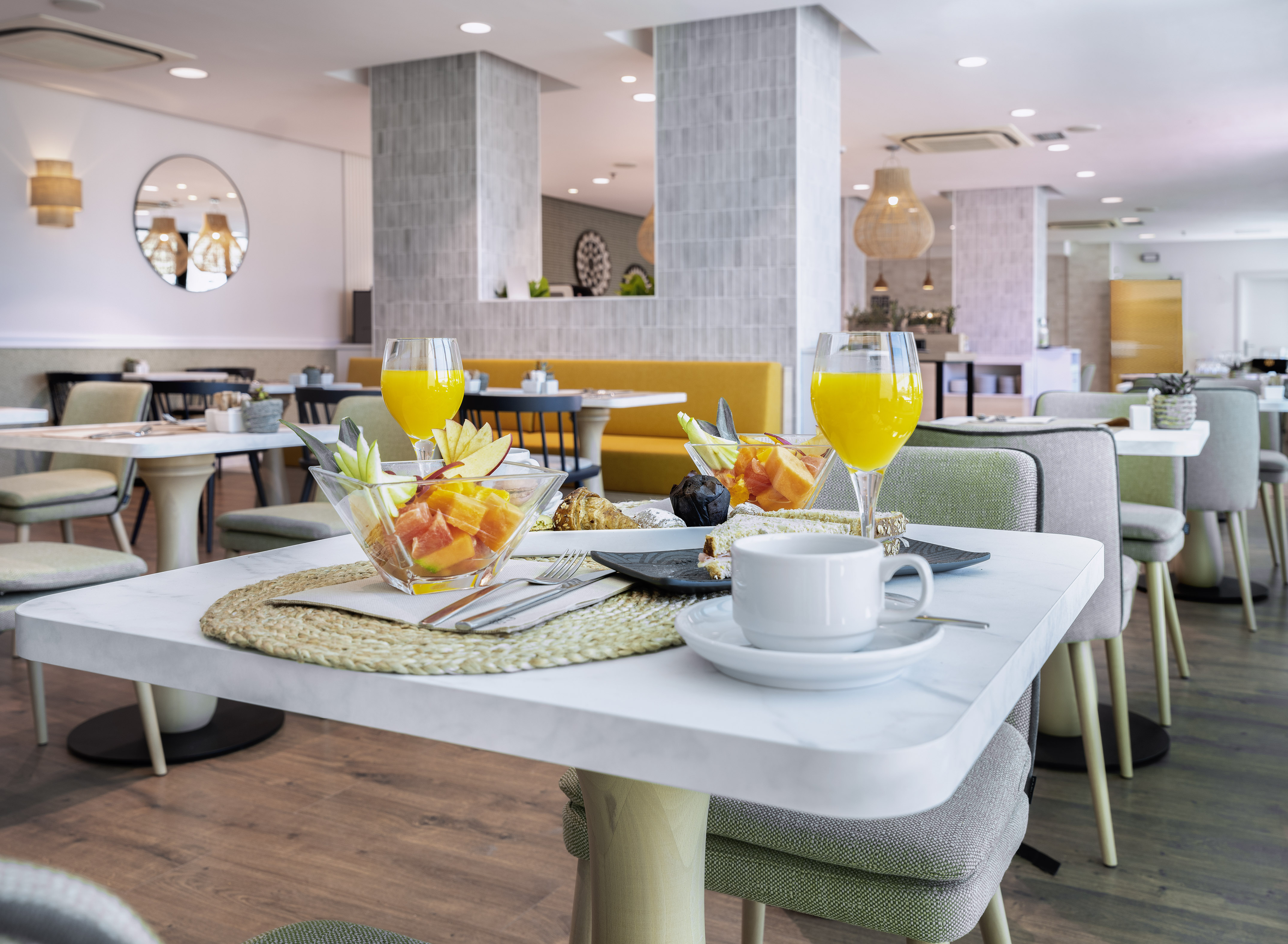 Hotel breakfast with fresh fruit, orange juice, coffee, and pastries.