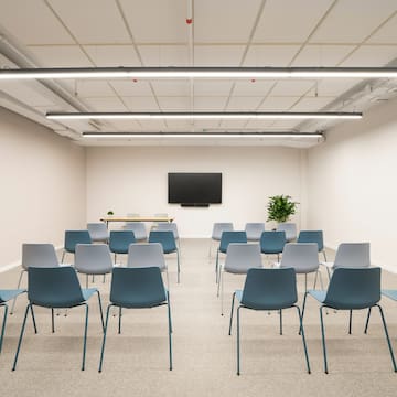 a room with many chairs and a tv