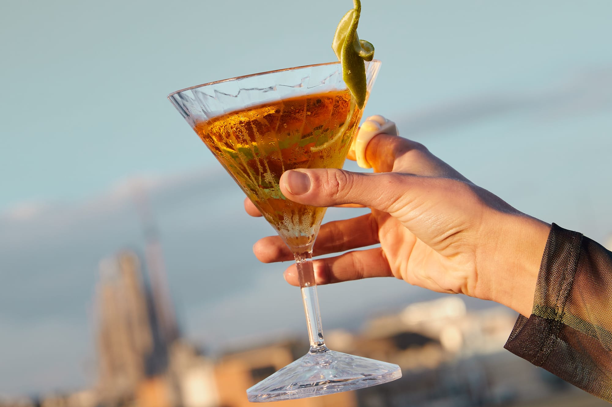 a hand holding a glass of liquid