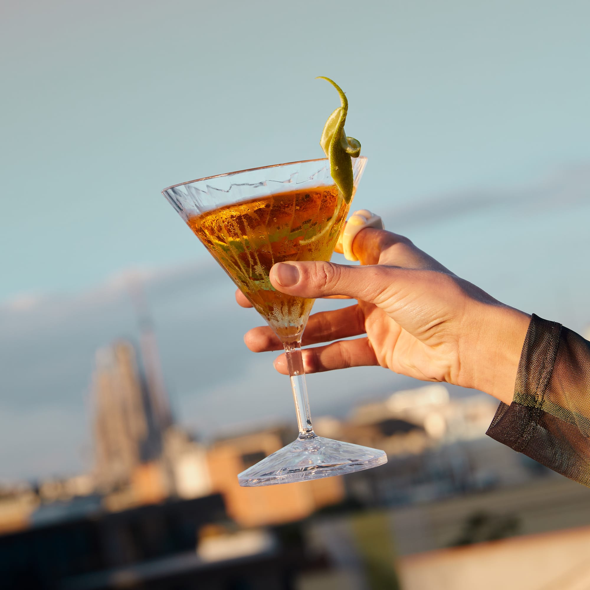 a hand holding a glass of liquid