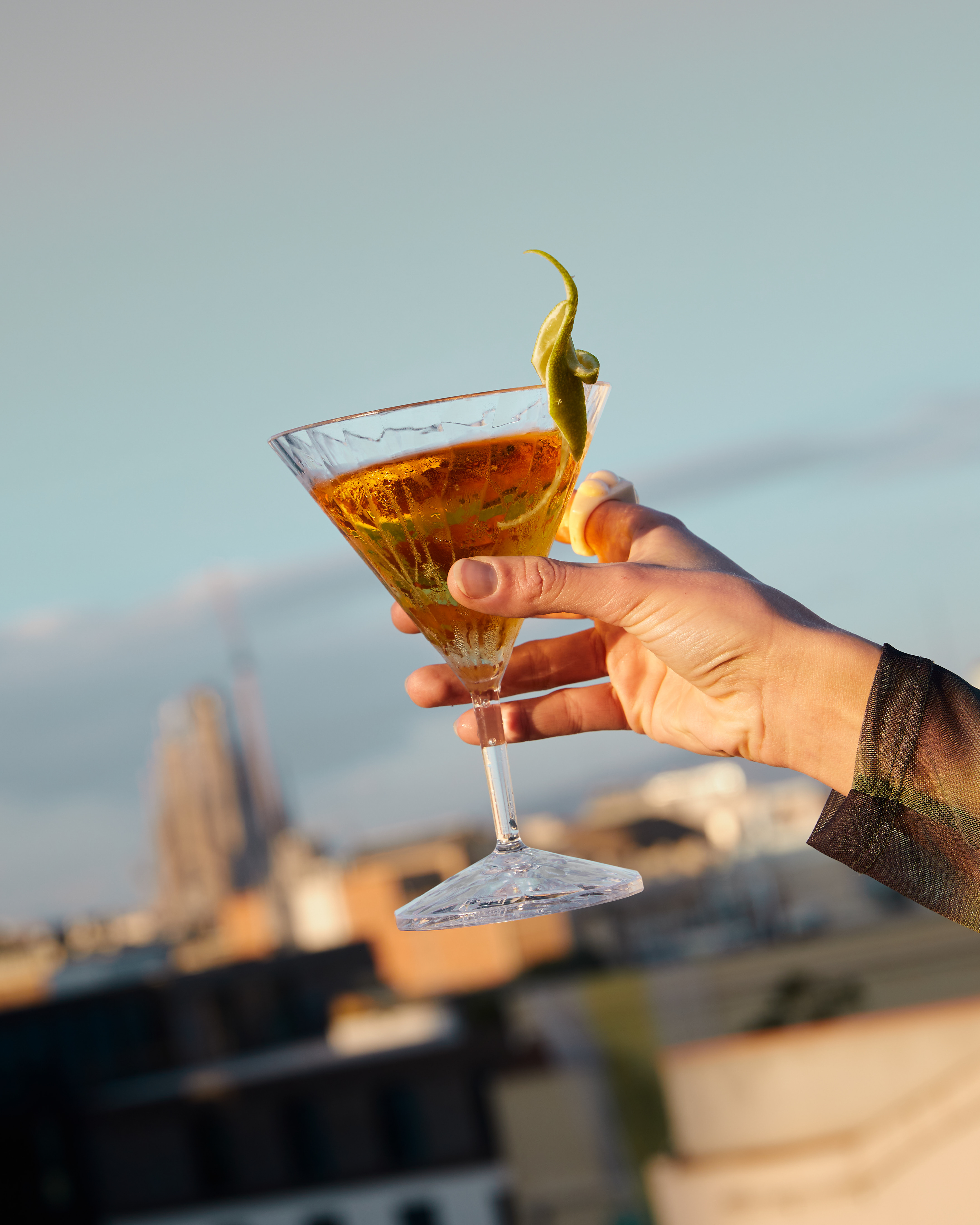 a hand holding a glass of liquid